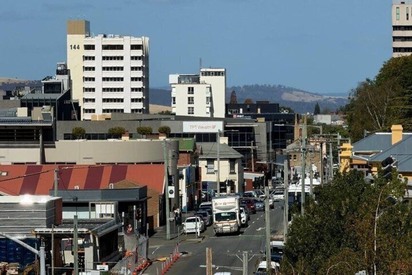 A city street with buildings, cars, and a clear sky. 3