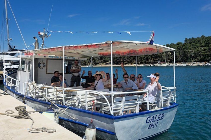A boat named 'GALER SPLIT' docked at a pier with people on board. 2