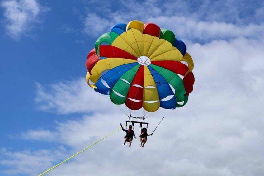 A person parachuting with a colorful parachute against a blue sky. 5