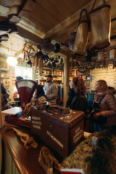 A bar with wooden shelves, hanging utensils, and a cash register. 3