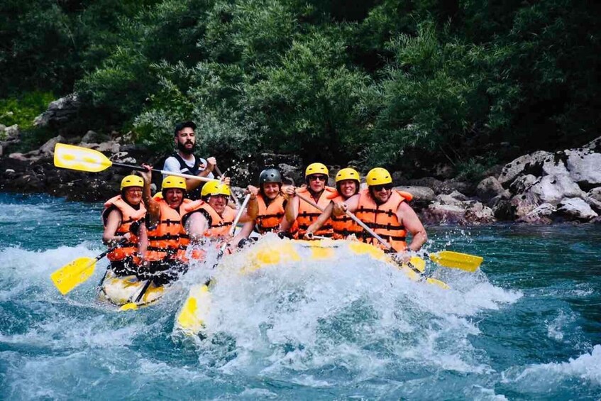 A group of people in a yellow raft navigating a river surrounded by greenery. 5