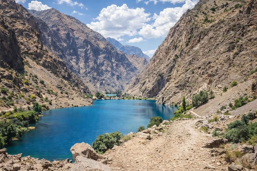 A mountainous landscape with a clear blue lake surrounded by rocky terrain and sparse vegetation. 1