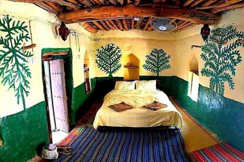 A room with a bed, green and yellow walls, and leaf patterns. 1