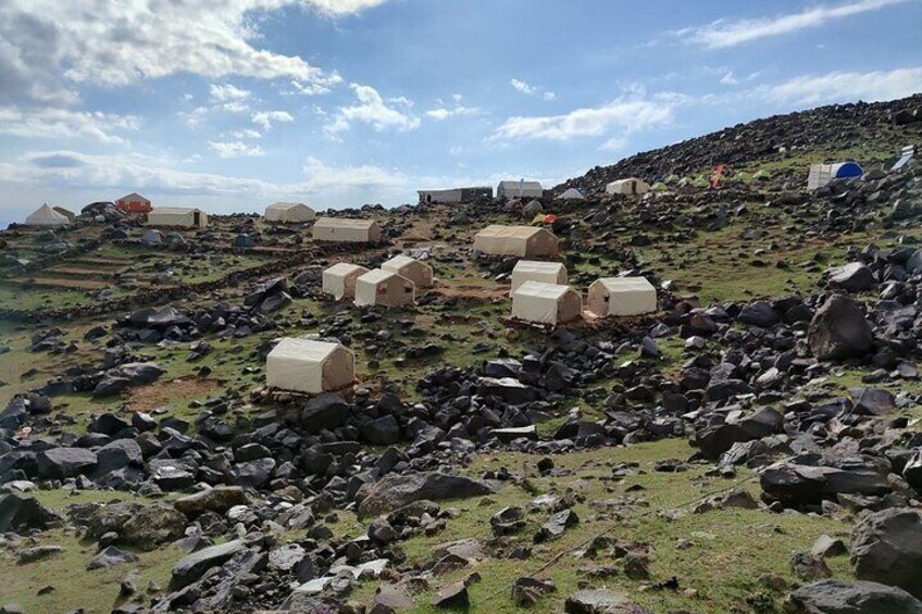 A rocky landscape with several small, beige-colored structures scattered across the terrain. 5