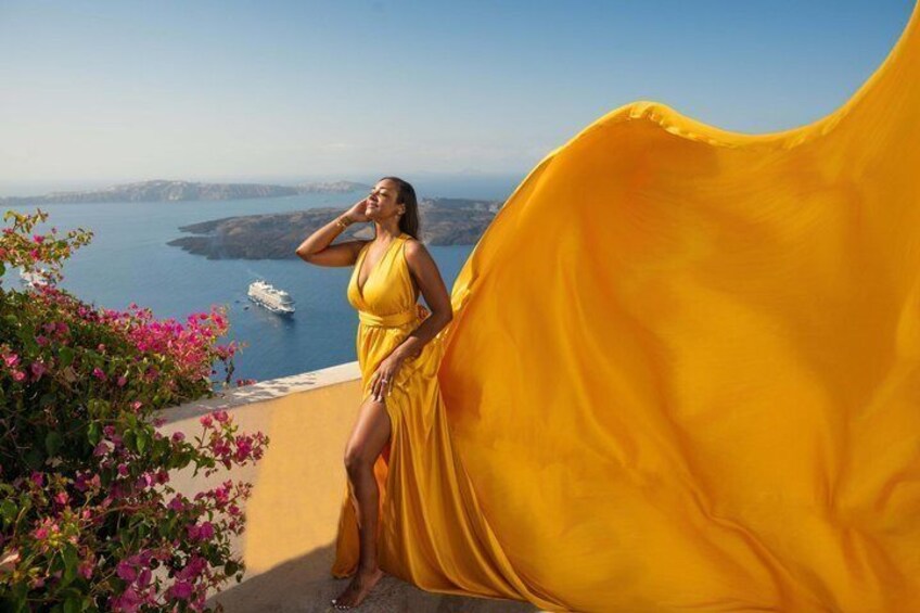 A woman in a yellow dress standing on a balcony overlooking a coastal landscape with a ship in the distance. 3