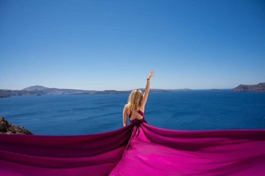 A person in a purple dress standing on a cliff overlooking a vast ocean with distant landforms. 4