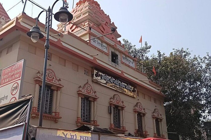 A temple with ornate architecture, a flag, and a sign indicating restricted hours. 3
