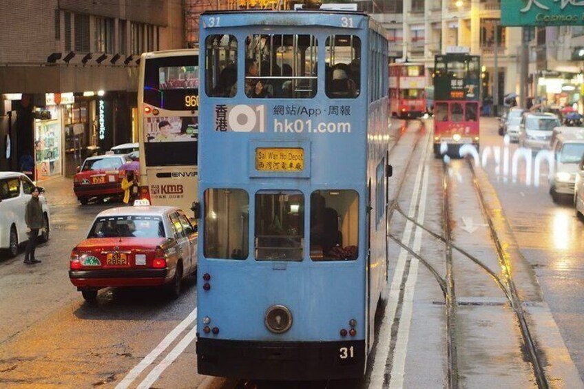 A blue double-decker bus on a wet street with cars and a red taxi. 5
