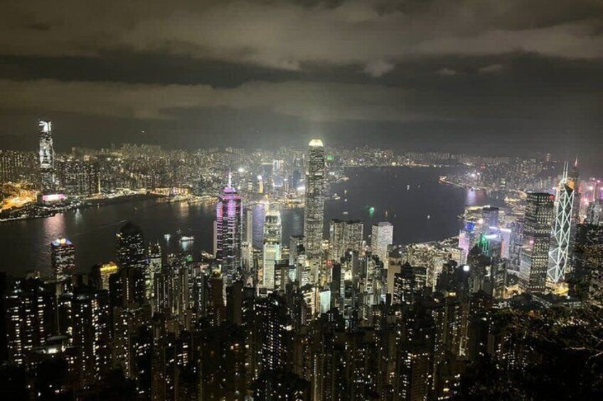 A nighttime cityscape with illuminated skyscrapers and a river. 3