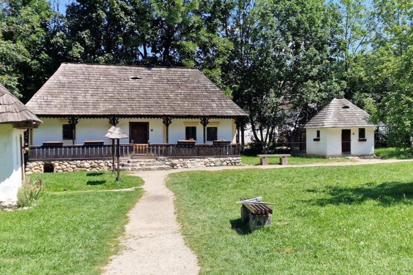 A traditional building with a thatched roof, surrounded by a grassy area and trees. 4