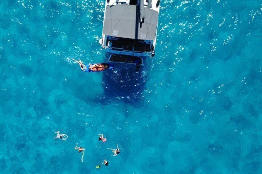 A boat with people swimming in the water. 3