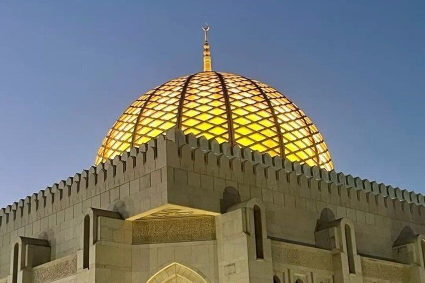 A large, illuminated dome with a geometric pattern, surrounded by a fortified wall. 5