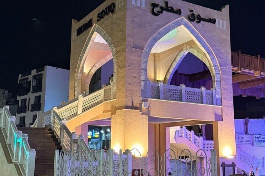 A building with arched entrances and a staircase leading up to it. 2