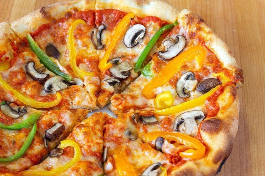 A pizza with toppings including mushrooms, green and yellow bell peppers, and cheese. 5