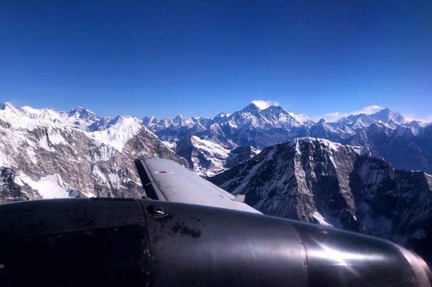 An airplane wing with a mountainous landscape in the background. 4
