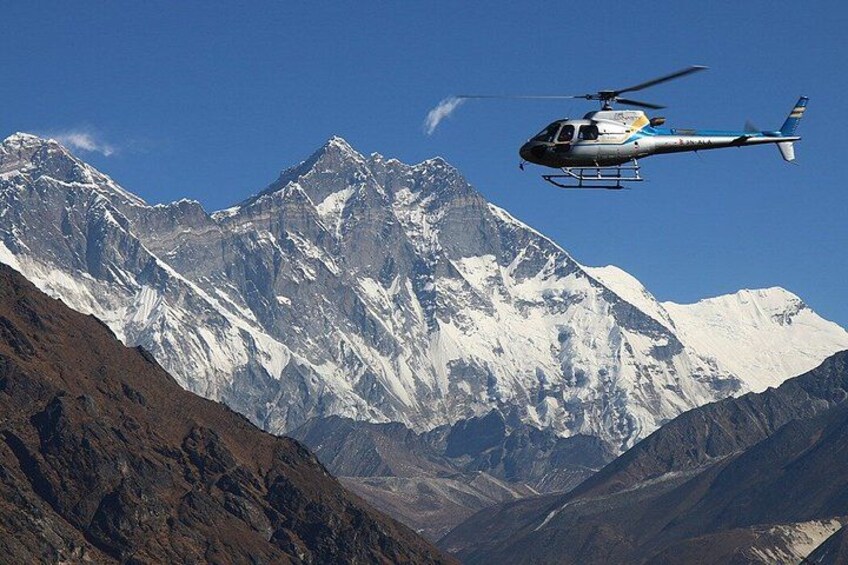 A helicopter flying over snow-capped mountains. 2