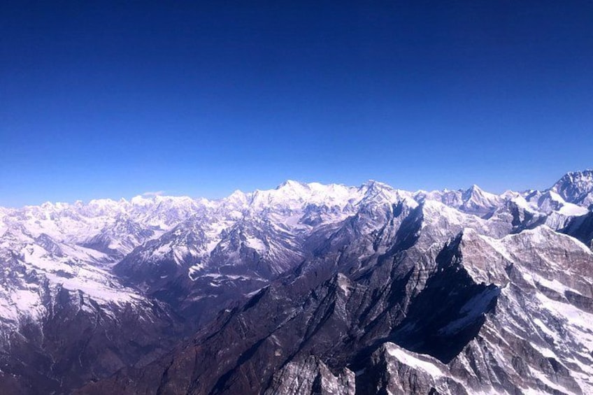 A mountain range with snow-covered peaks under a clear blue sky. 5