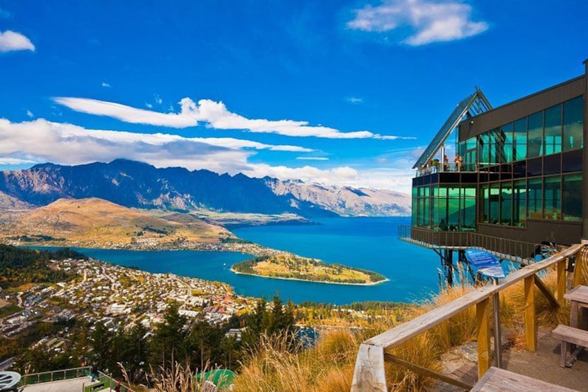 A high vantage point overlooking a lake, mountains, and a town below. 4