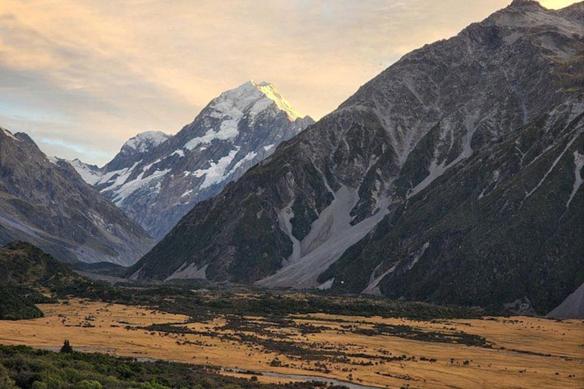 A mountainous landscape with a prominent peak, a valley, and a river. 3