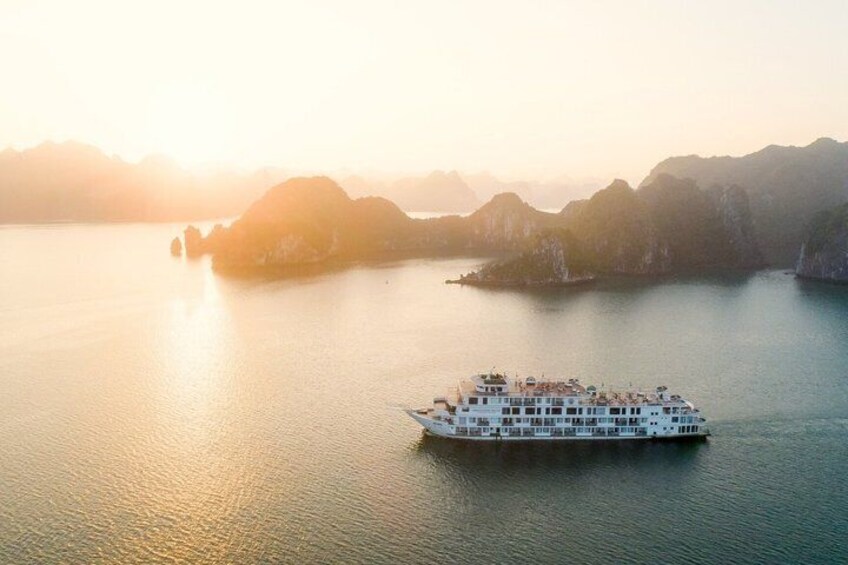 Un'ampia nave da crociera bianca su acque calme, con isole montuose sullo sfondo. 1