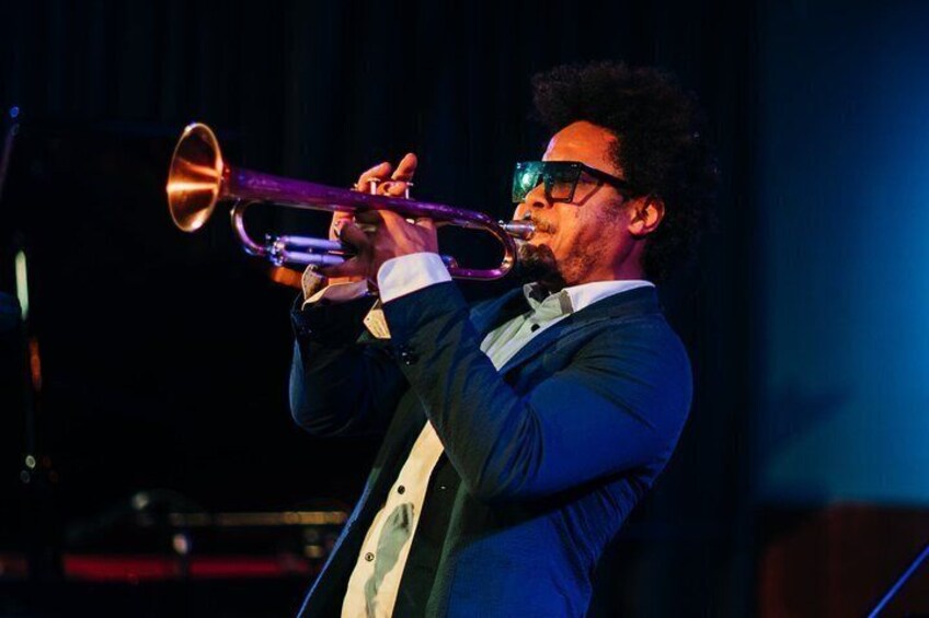 En person som spelar trumpet på scenen. 1