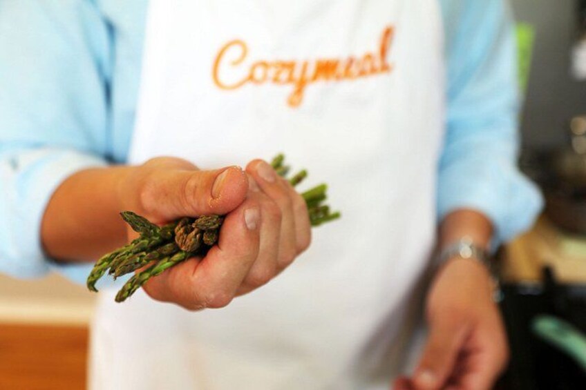 Eine Person hält Spargel und trägt eine weiße Schürze mit dem Aufdruck 'Cozymmeal'. 2