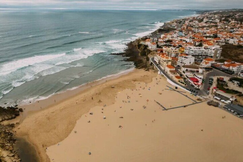 A coastal town with a beach, ocean, and buildings. 2