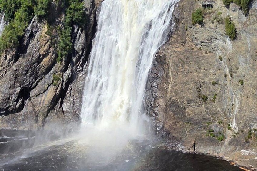 A waterfall cascading down a rocky cliff, surrounded by sparse vegetation. 3