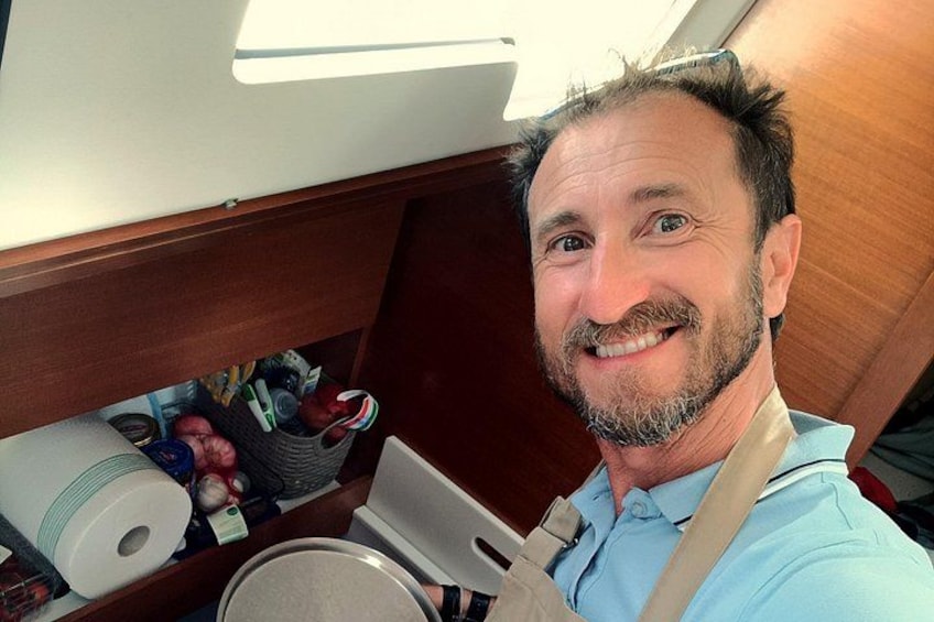 Una persona con camisa azul claro sosteniendo un objeto enrollado, con un mueble de madera y varios objetos al fondo. 2