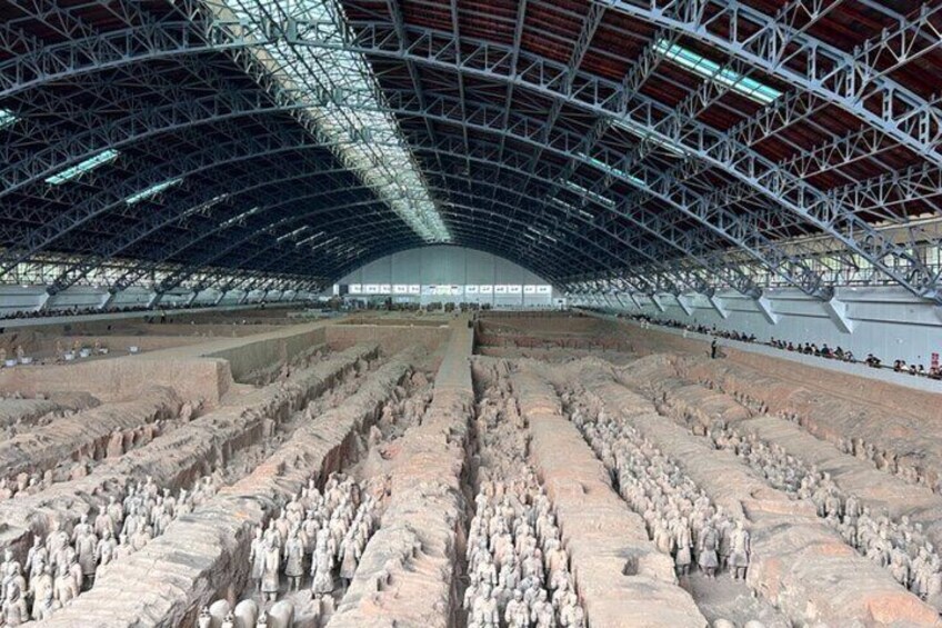 A large indoor space with a high ceiling and rows of stone statues. 4