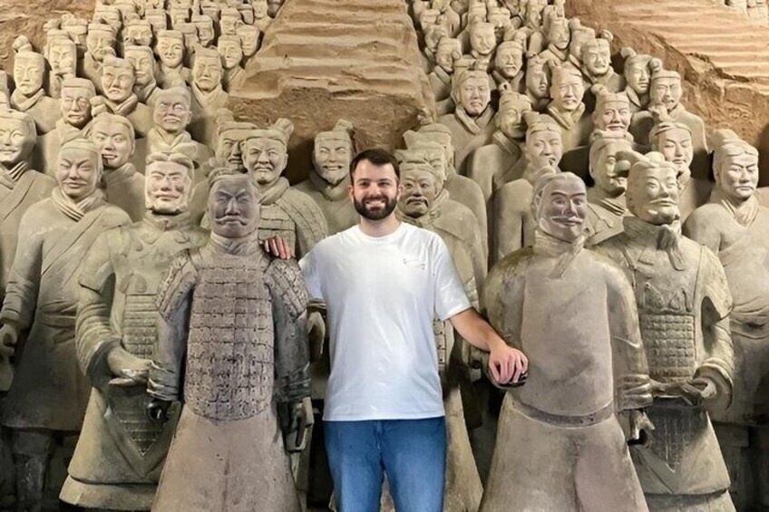 A person standing in front of a large stone sculpture of soldiers. 2