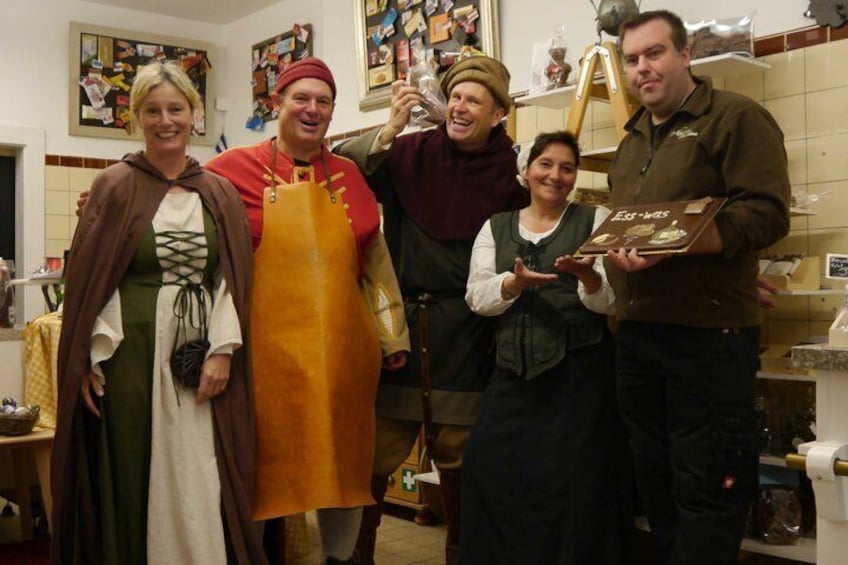 A group of people in a kitchen, some wearing medieval costumes. 2