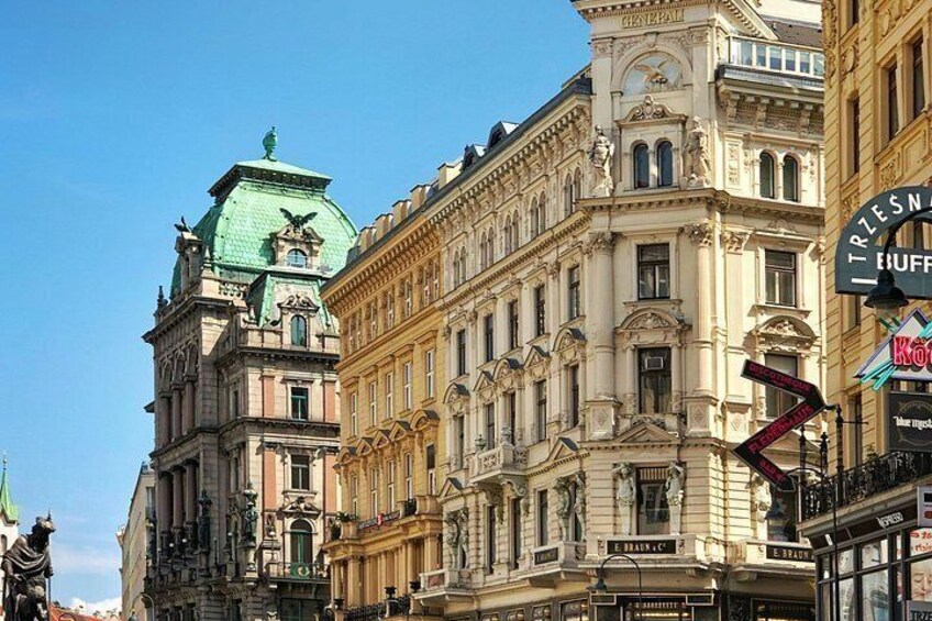 A historic building with ornate architecture, a green dome, and a sign for a hotel. 5