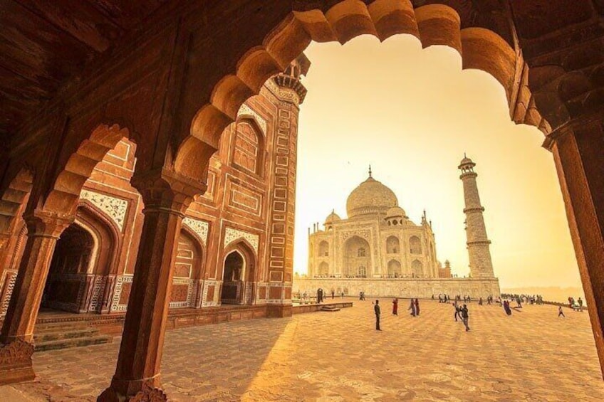 The Taj Mahal with a large archway in the foreground. 1