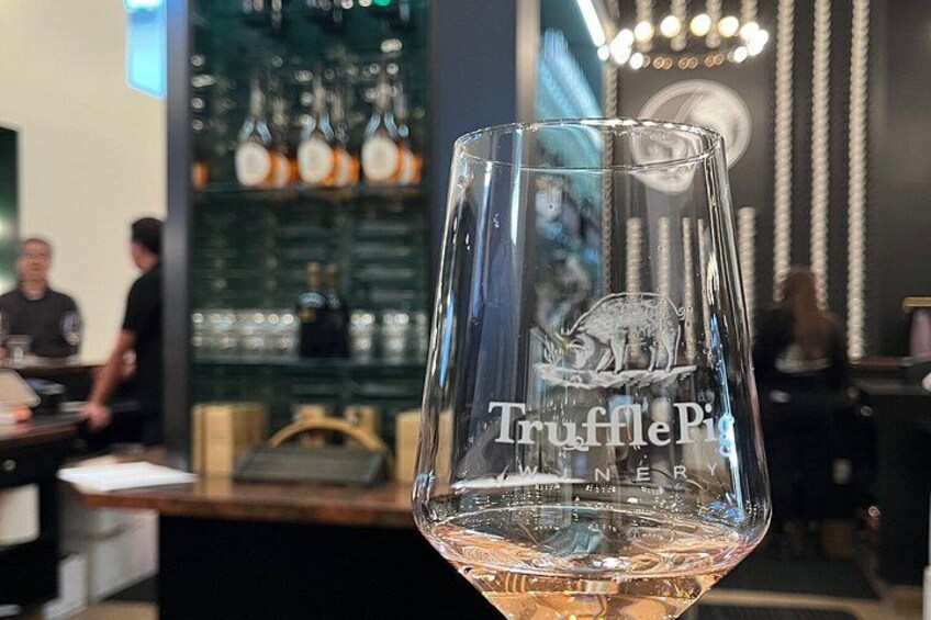A glass with the inscription 'TrufflePig' in a bar setting. 2