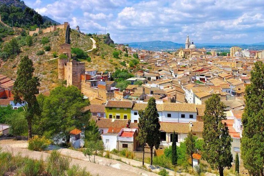 A town with historic architecture, a prominent church, and a castle on a hill. 2