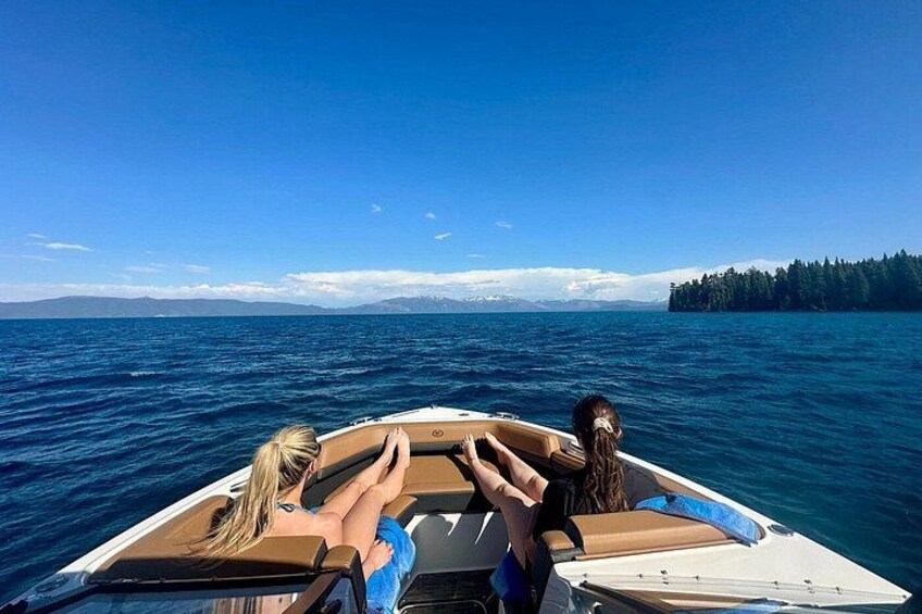 A boat on a body of water with a forested island in the background. 2