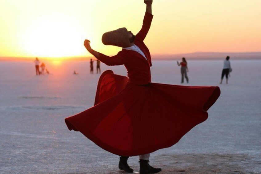 A person in a red dress dancing on a beach at sunset. 5