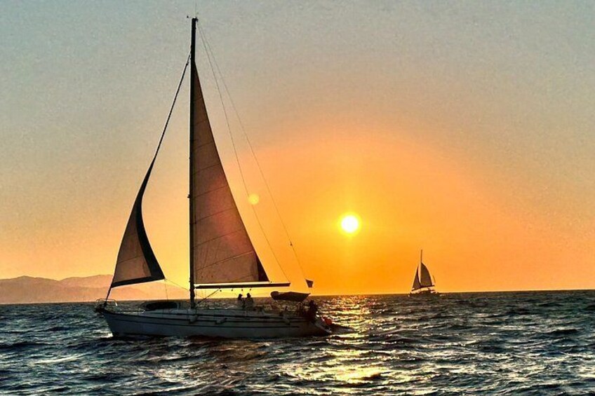 A sailboat on the water with a sunset in the background. 2