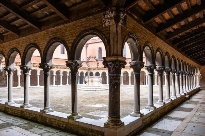 An indoor courtyard with a series of arches and columns. 3
