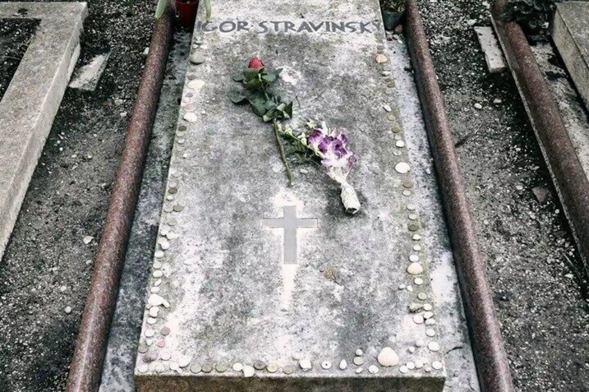 A gravestone with a cross, a rose, and a name inscription. 4