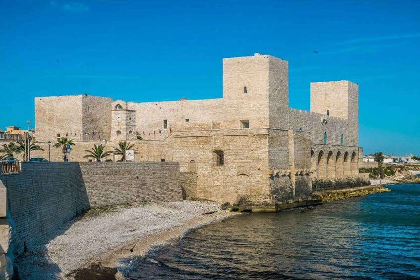 A historic stone fortress by the sea with a clear sky. 3