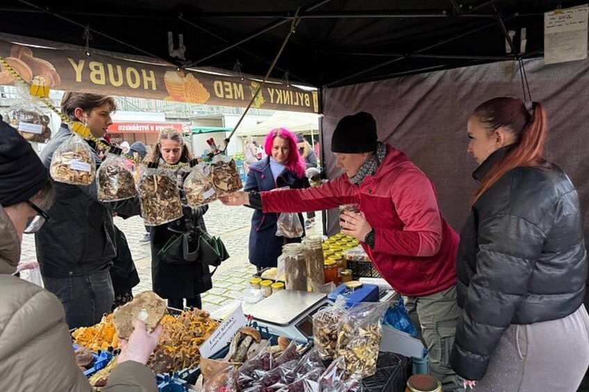 A street market with people buying and selling goods. 2