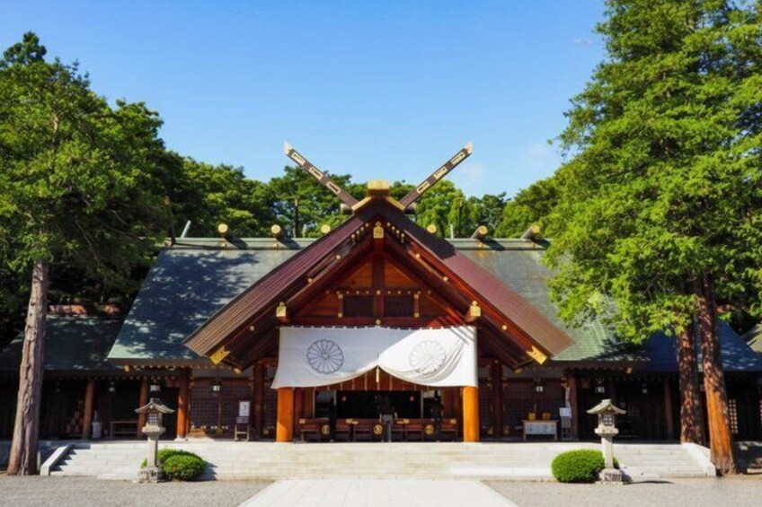 A traditional Japanese building with a tiled roof, wooden beams, and a large banner. 4