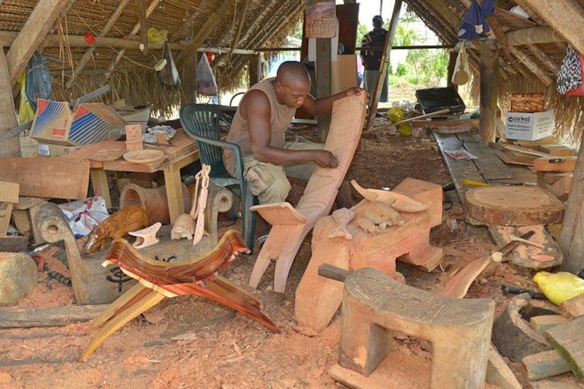 A person working with wood in a workshop with various tools and unfinished wooden pieces. 2