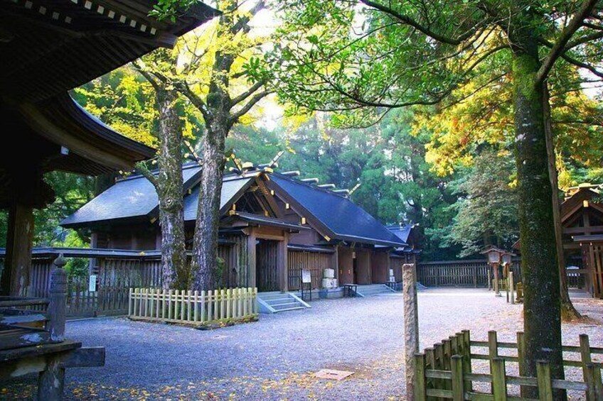 A traditional Japanese building surrounded by trees and a wooden fence. 4