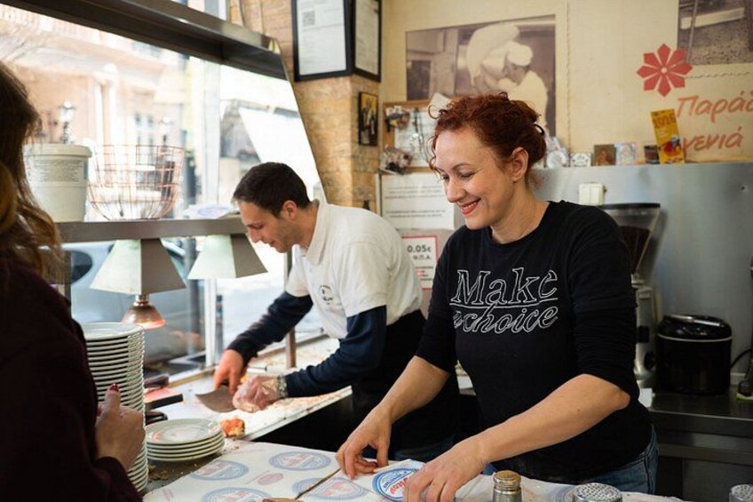 Une personne portant un t-shirt noir sur lequel est imprimé le message « Faites un choix », se tient devant un comptoir où se trouve un menu. 2