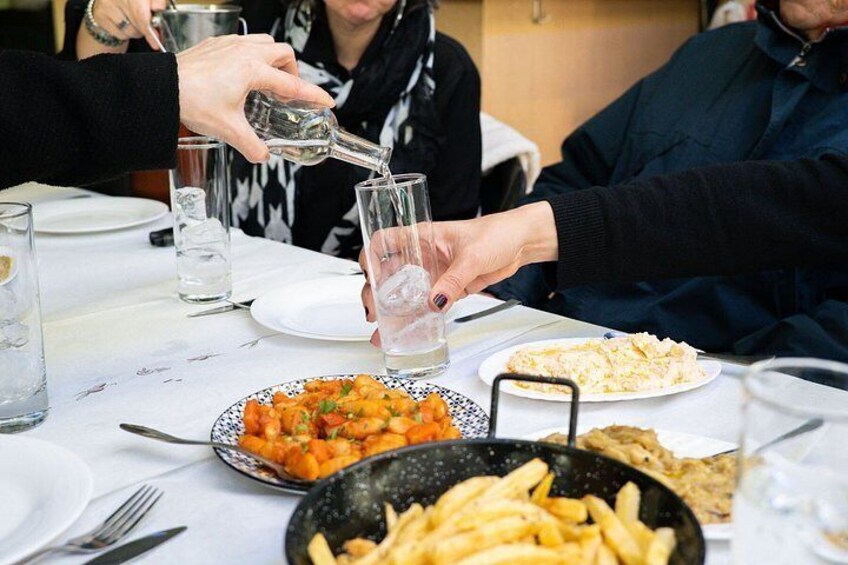 Des personnes sont assises autour d'une table, devant des assiettes remplies de nourriture et des verres d'eau. 5