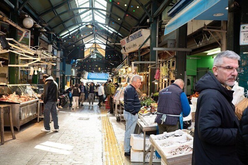 Un marché couvert où les gens font leurs courses et où des vendeurs proposent leurs produits. 4