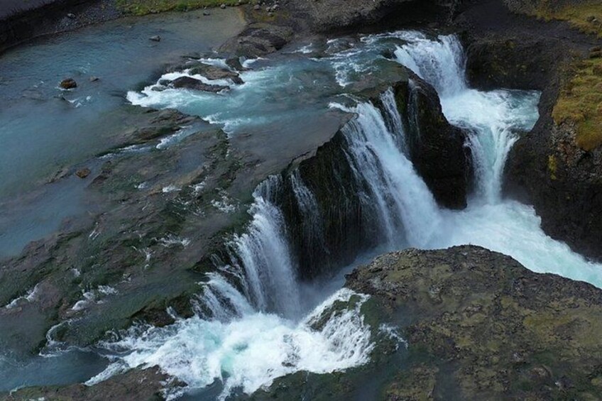 A waterfall cascading over rocks into a river. 3